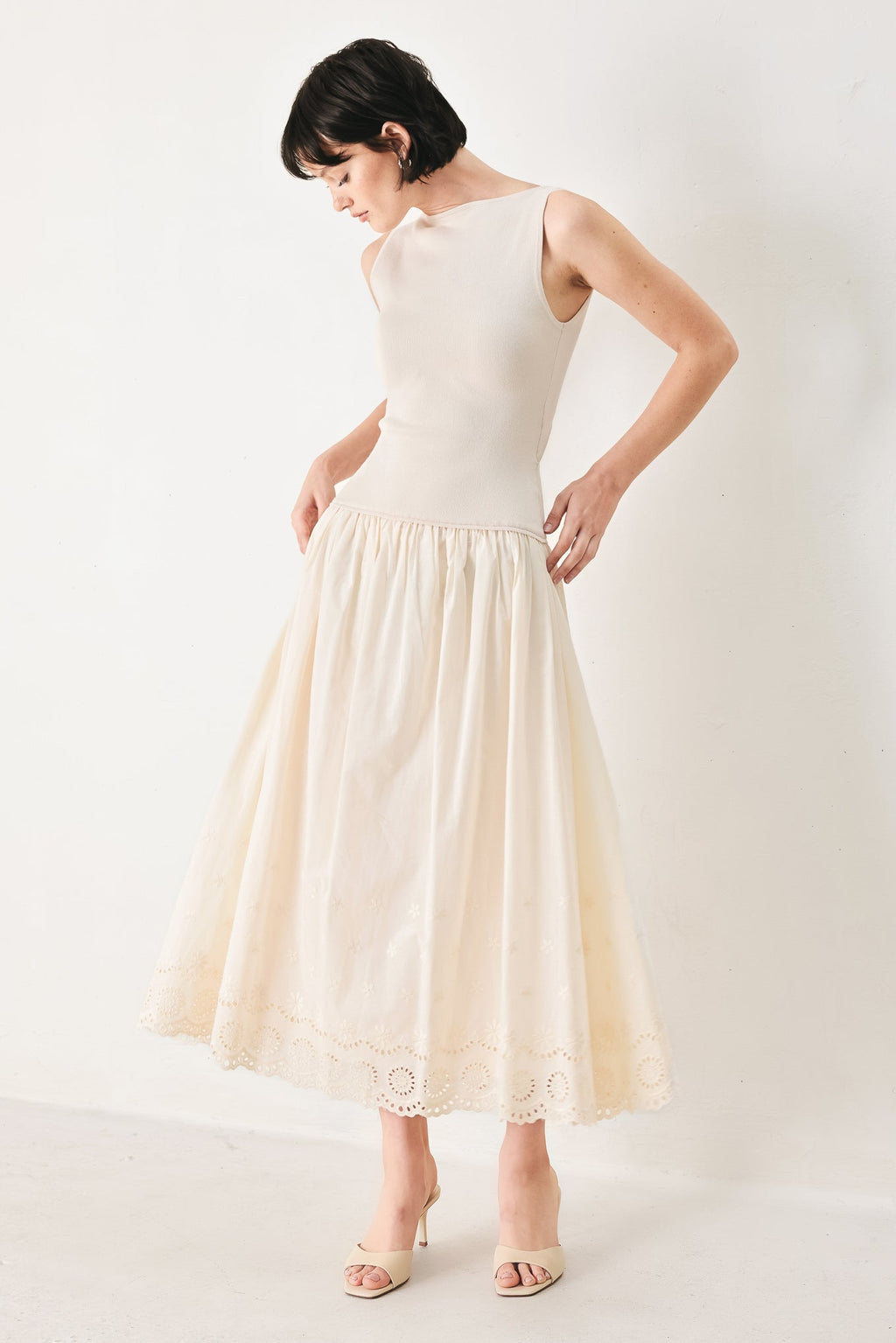 Daydream Thread Midi Dress in Light Taupe with sweater knit top, round neckline, sleeveless cut, drop waist, woven eyelet skirt, and cut out at waist shown on model