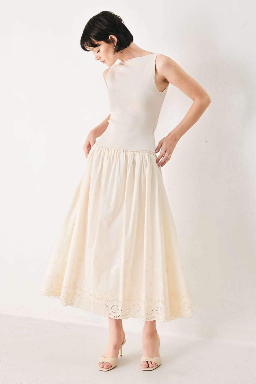 Daydream Thread Midi Dress in Light Taupe with sweater knit top, round neckline, sleeveless cut, drop waist, woven eyelet skirt, and cut out at waist shown on model