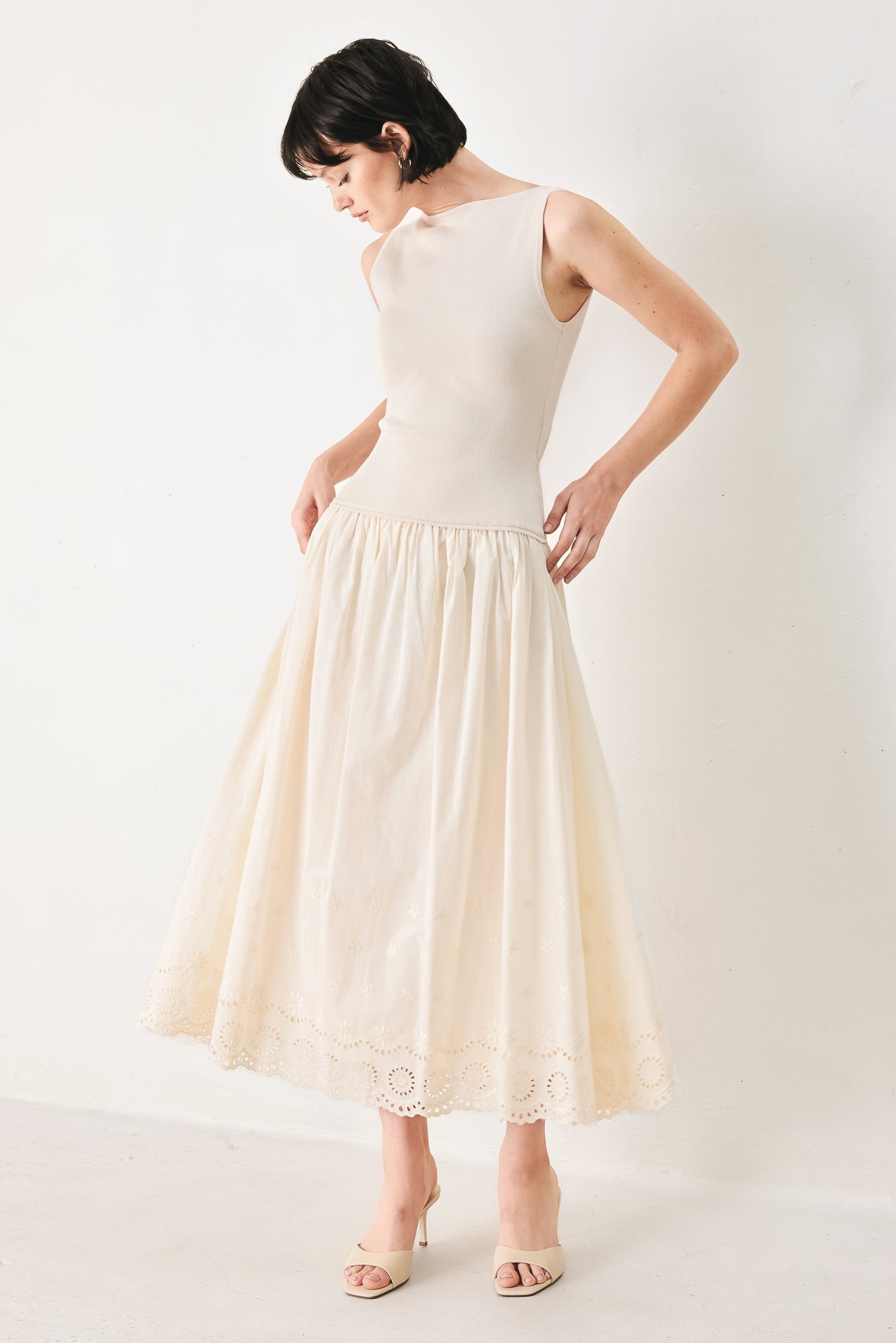 Daydream Thread Midi Dress in Light Taupe with sweater knit top, round neckline, sleeveless cut, drop waist, woven eyelet skirt, and cut out at waist shown on model