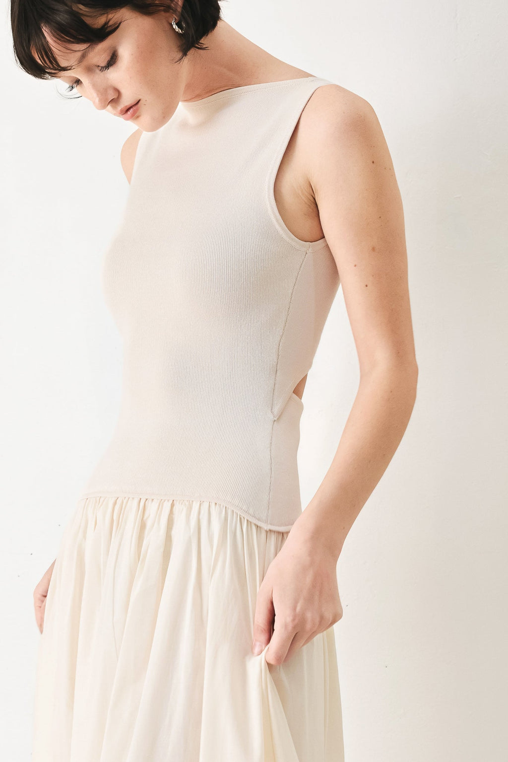 Daydream Thread Midi Dress in Light Taupe with sweater knit top, round neckline, sleeveless cut, drop waist, woven eyelet skirt, and cut out at waist shown on model