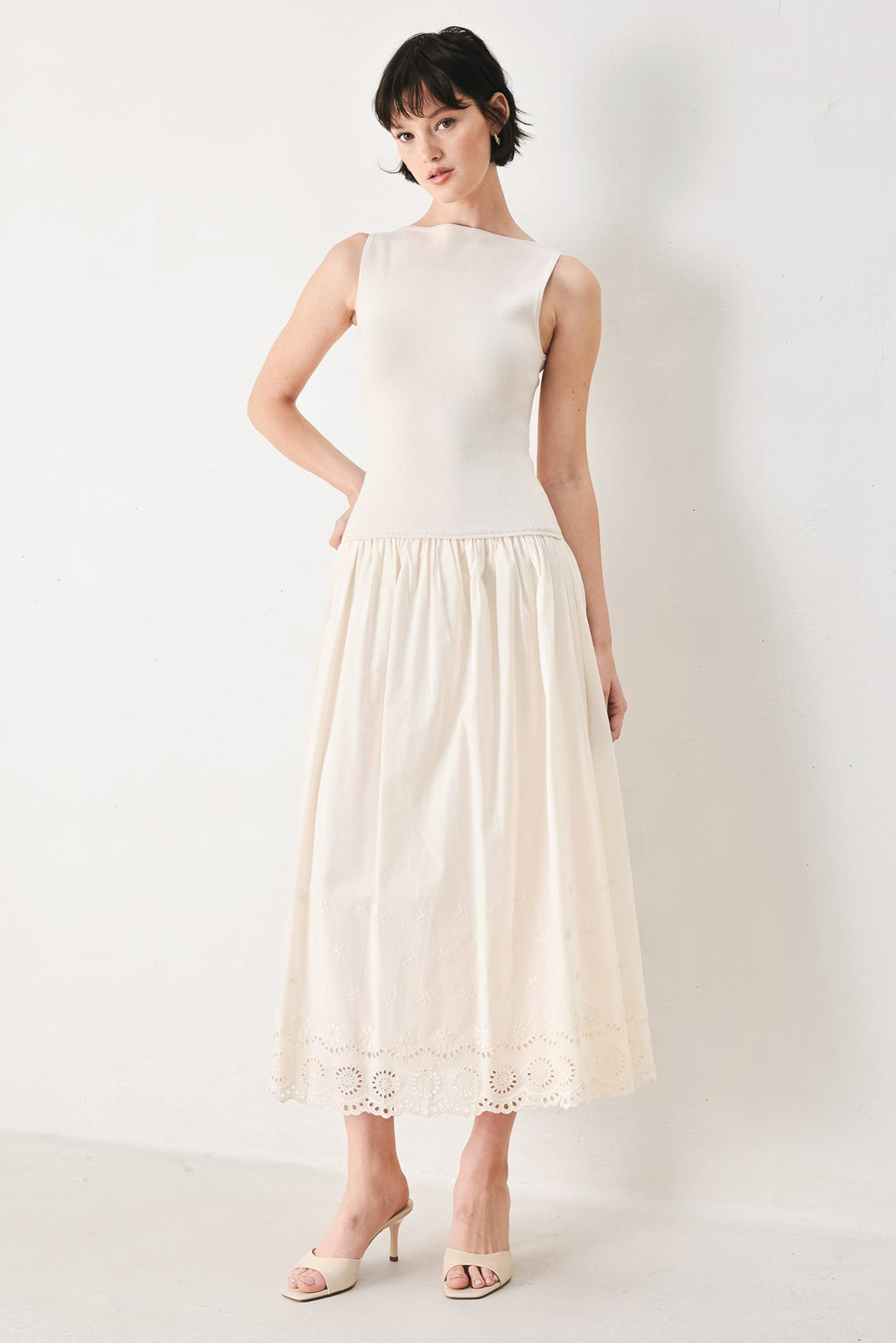 Daydream Thread Midi Dress in Light Taupe with sweater knit top, round neckline, sleeveless cut, drop waist, woven eyelet skirt, and cut out at waist shown on model