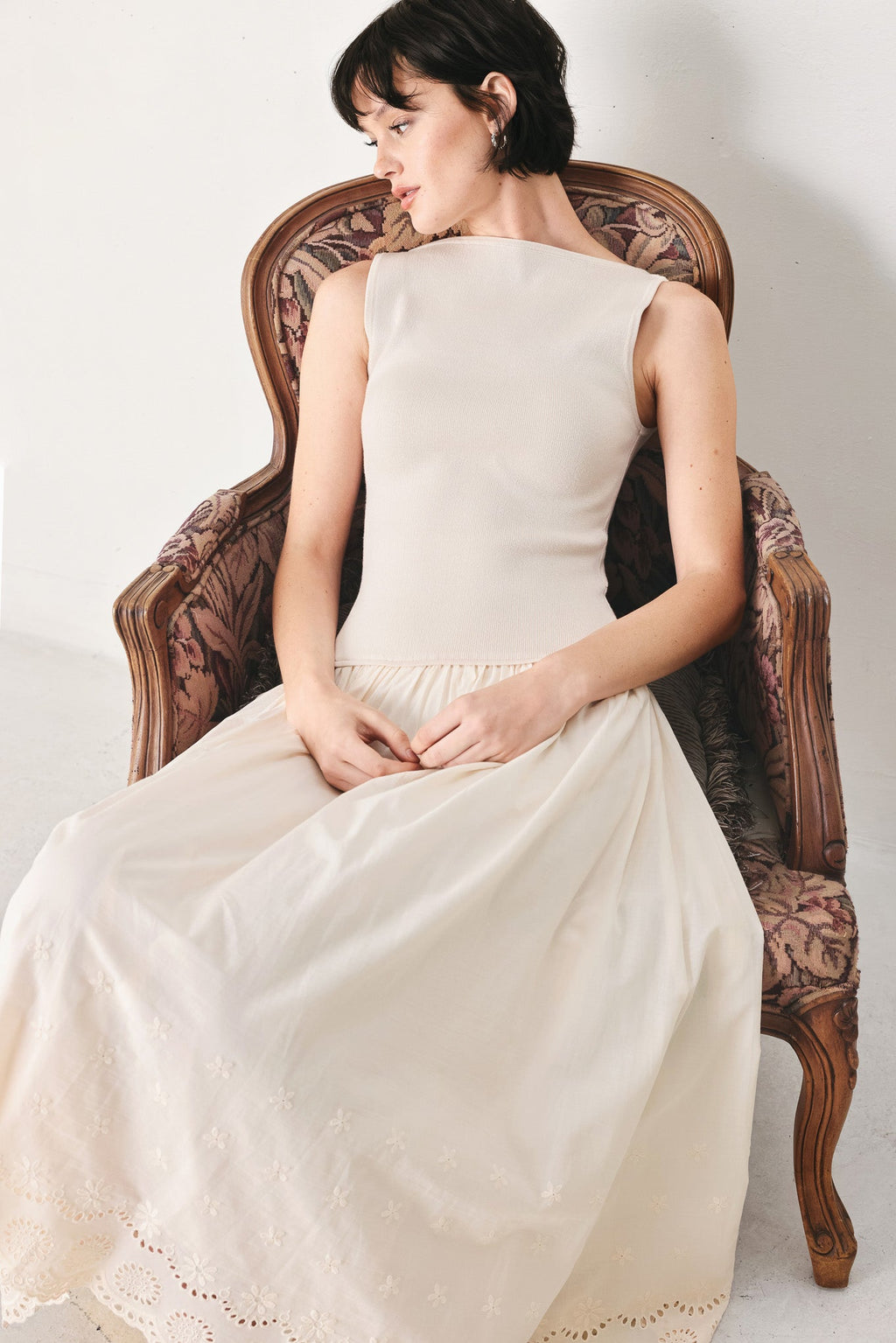 Daydream Thread Midi Dress in Light Taupe with sweater knit top, round neckline, sleeveless cut, drop waist, woven eyelet skirt, and cut out at waist shown on model