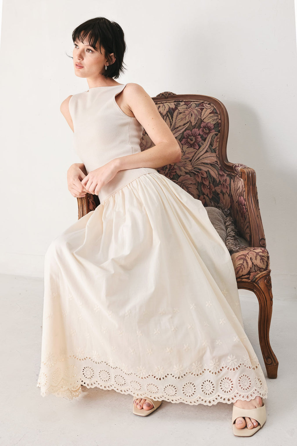 Daydream Thread Midi Dress in Light Taupe with sweater knit top, round neckline, sleeveless cut, drop waist, woven eyelet skirt, and cut out at waist shown on model