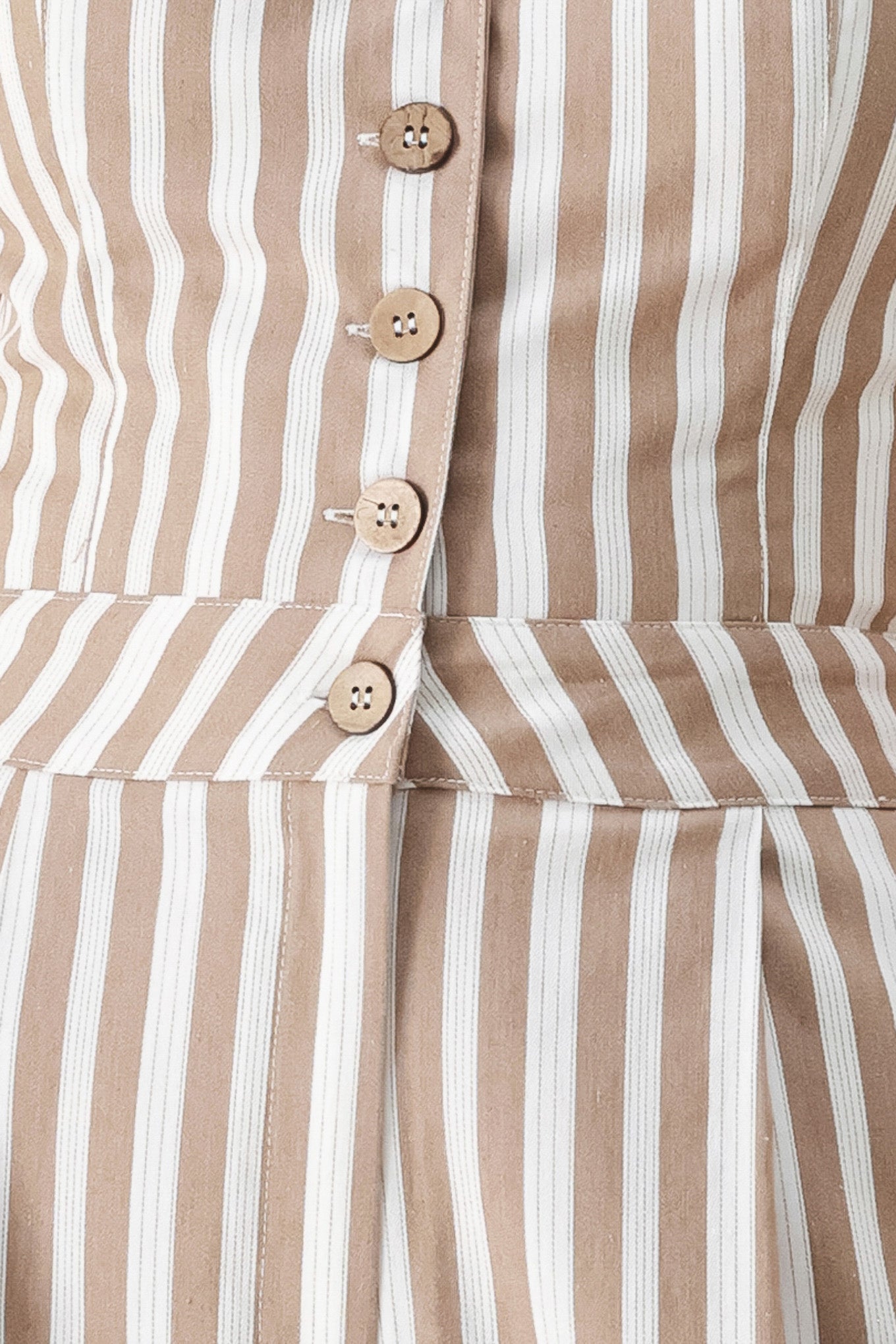 Natural Rhythm Woven Jumpsuit in Taupe White with stripe print, V-neckline, sleeveless cut, front button closure, and wide leg shown on model