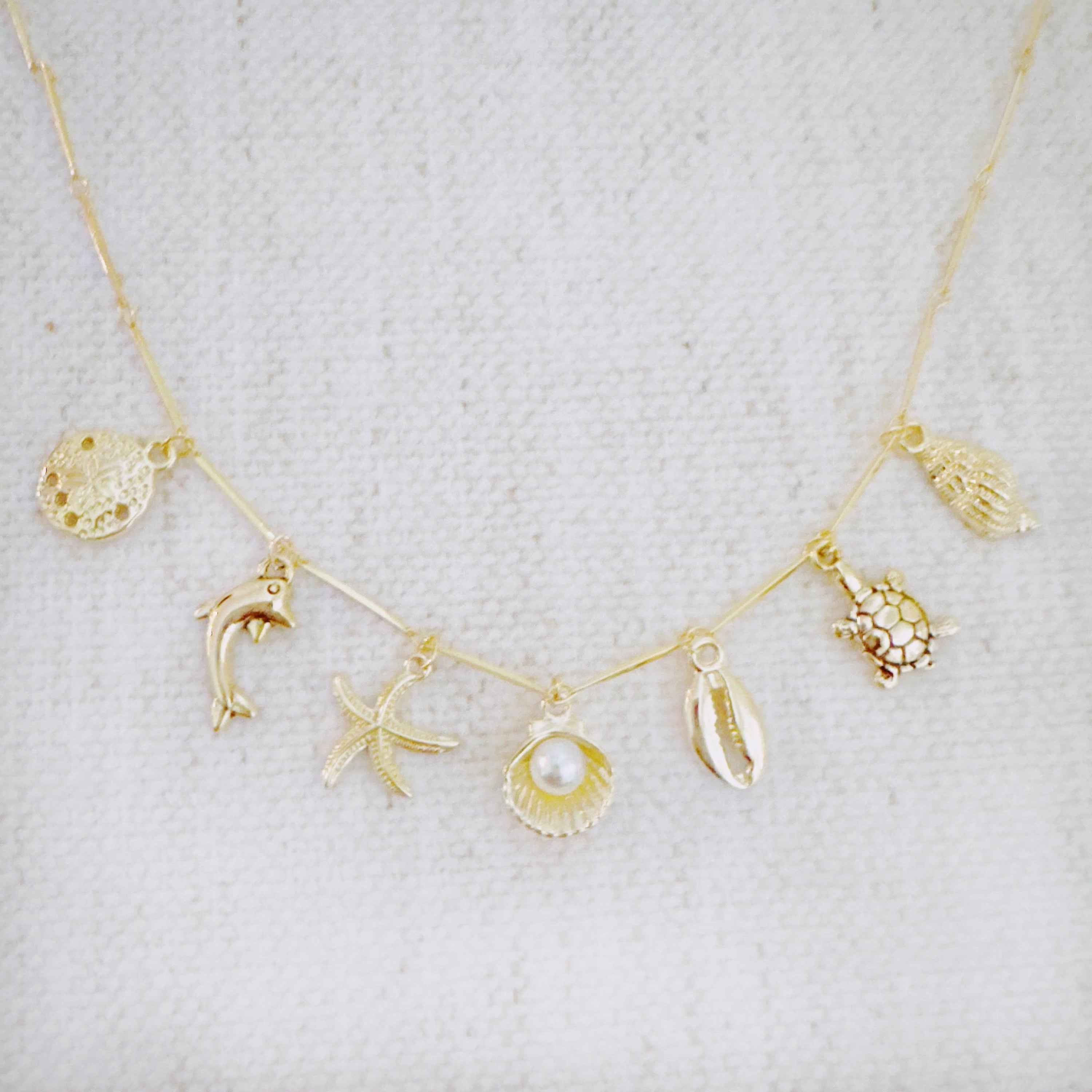 Golden Sea Charm Necklace - close up of ocean charms