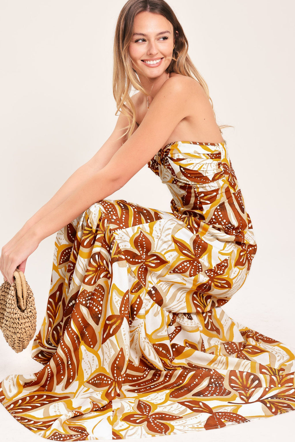 Amber Palm Paradise Woven Maxi Dress in Mustard Brown with palm print, halter tie neckline, ruffle hem, and back zipper closure shown on model