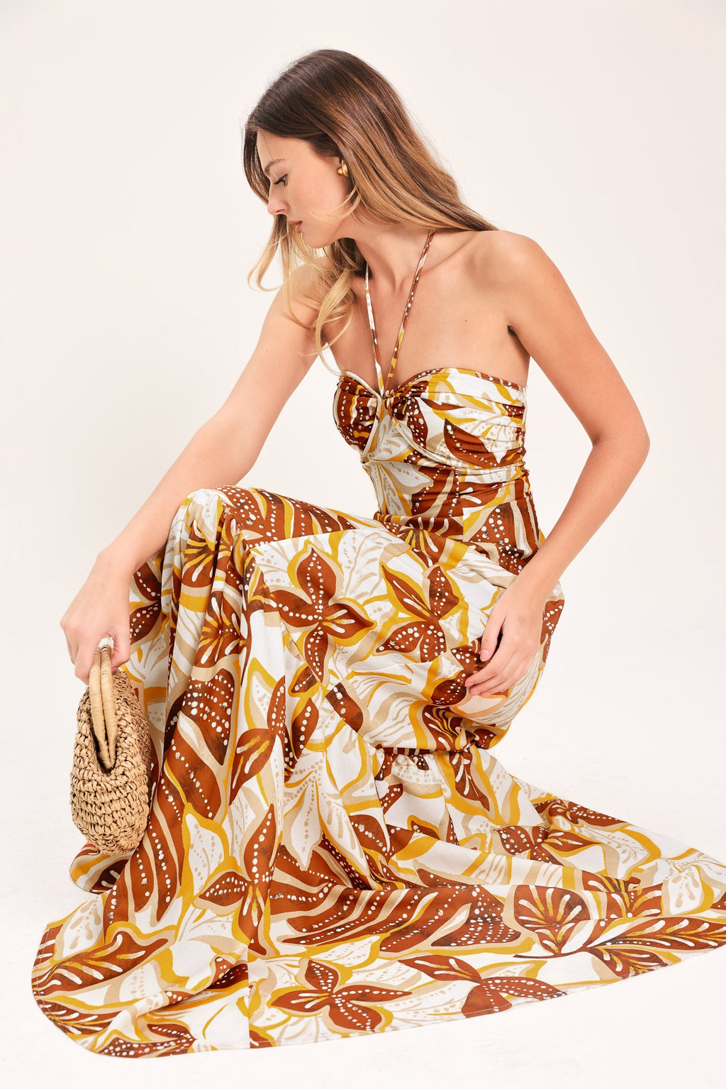 Amber Palm Paradise Woven Maxi Dress in Mustard Brown with palm print, halter tie neckline, ruffle hem, and back zipper closure shown on model