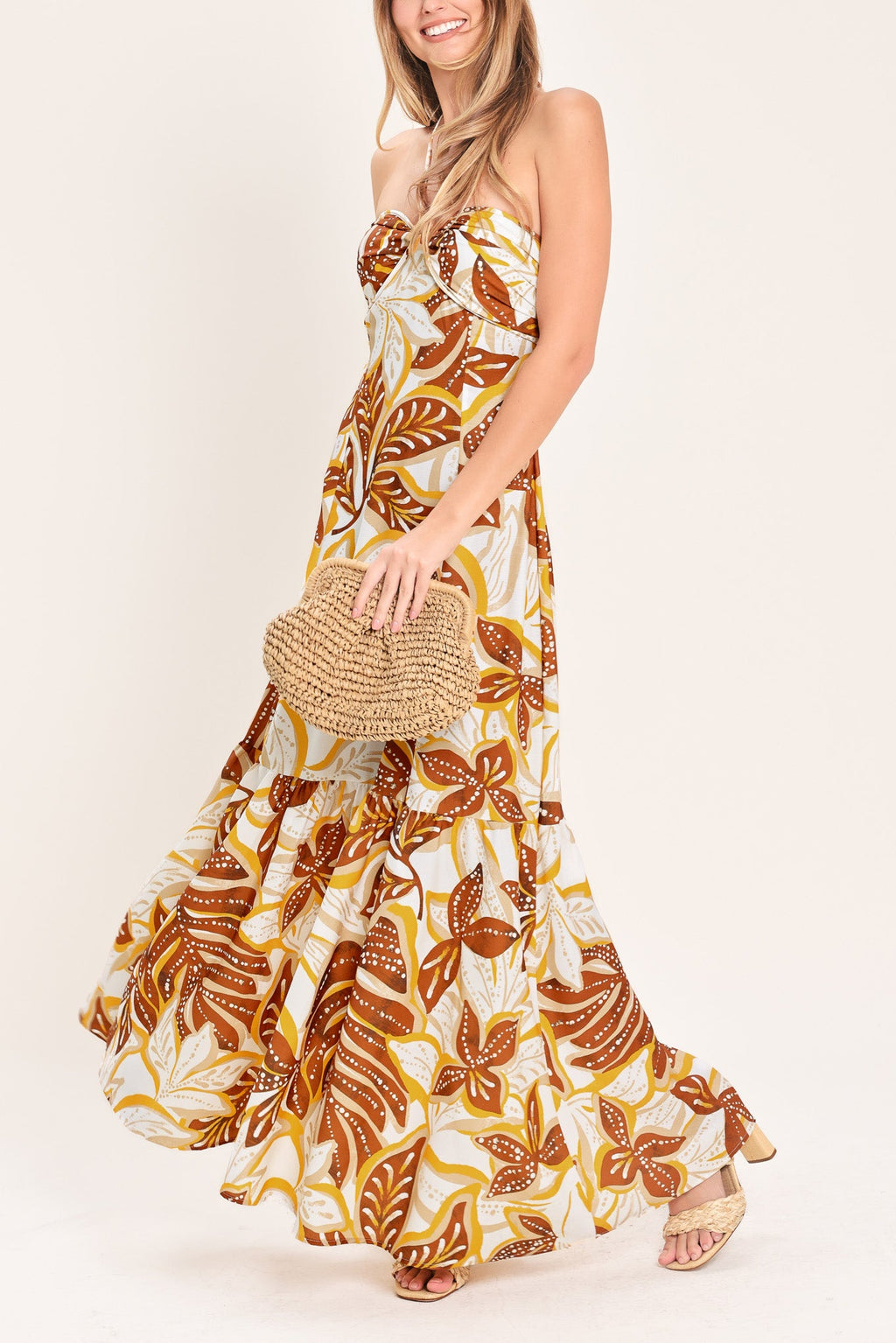 Amber Palm Paradise Woven Maxi Dress in Mustard Brown with palm print, halter tie neckline, ruffle hem, and back zipper closure shown on model