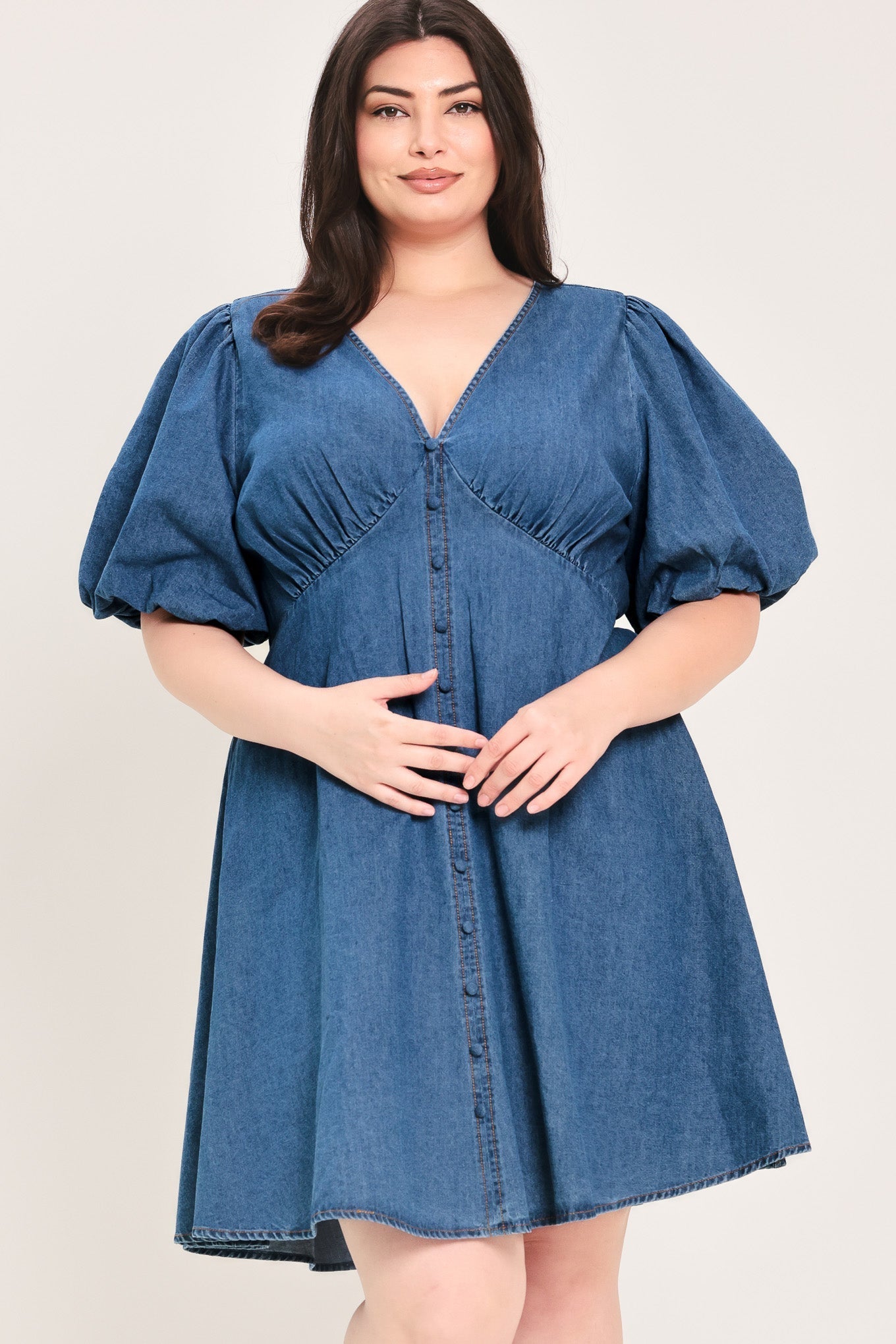 Soft Girl Denim Mini Dress in Medium Indigo Plus with V-neckline, puff sleeves, button-down detail, and circle skirt shown on model