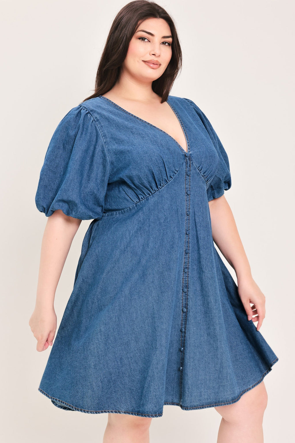 Soft Girl Denim Mini Dress in Medium Indigo Plus with V-neckline, puff sleeves, button-down detail, and circle skirt shown on model