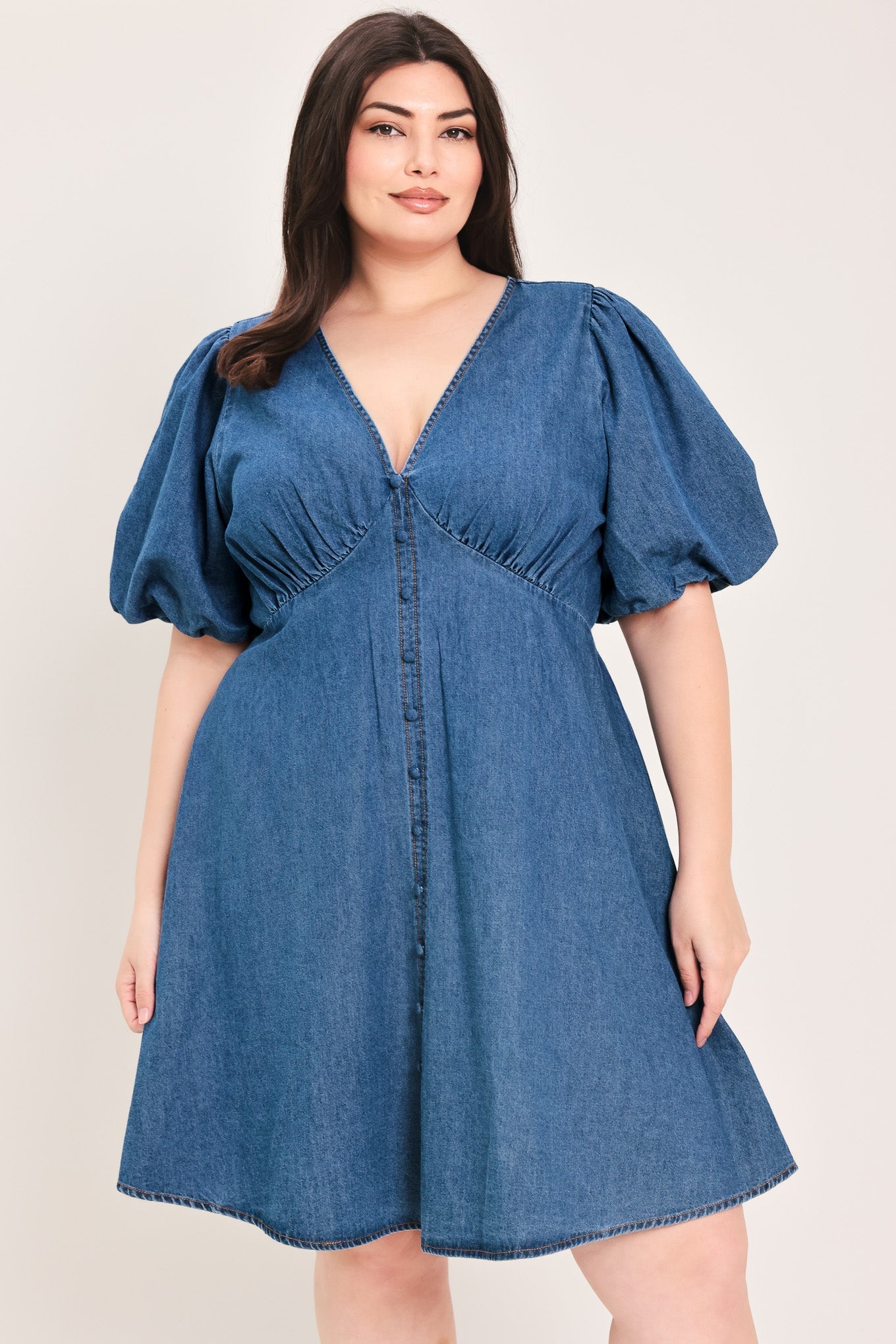 Soft Girl Denim Mini Dress in Medium Indigo Plus with V-neckline, puff sleeves, button-down detail, and circle skirt shown on model