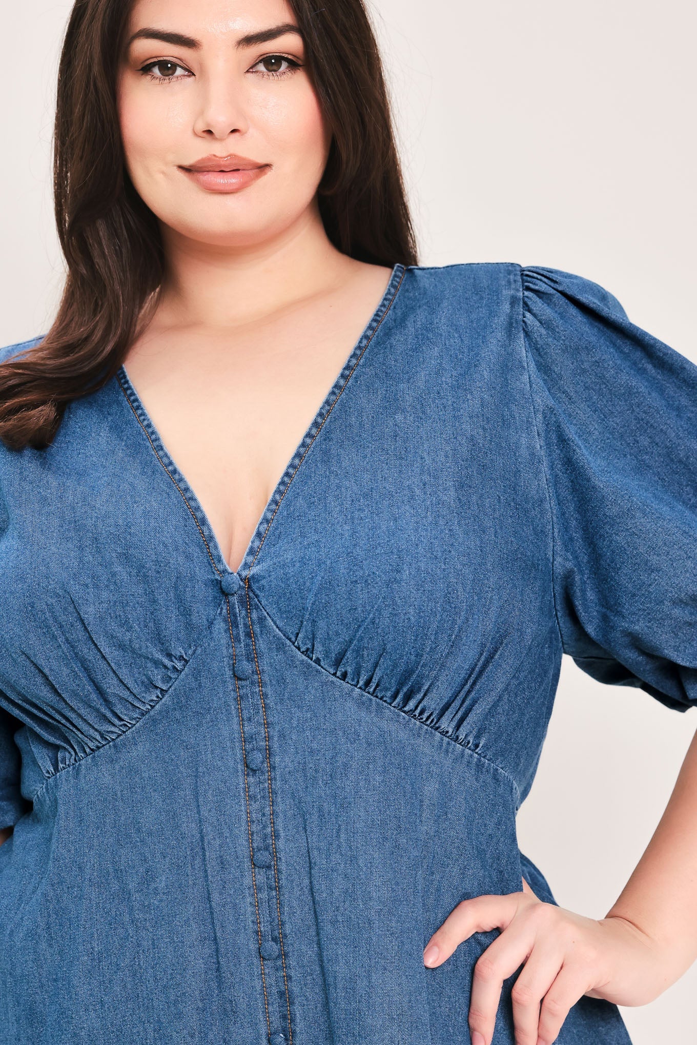 Soft Girl Denim Mini Dress in Medium Indigo Plus with V-neckline, puff sleeves, button-down detail, and circle skirt shown on model