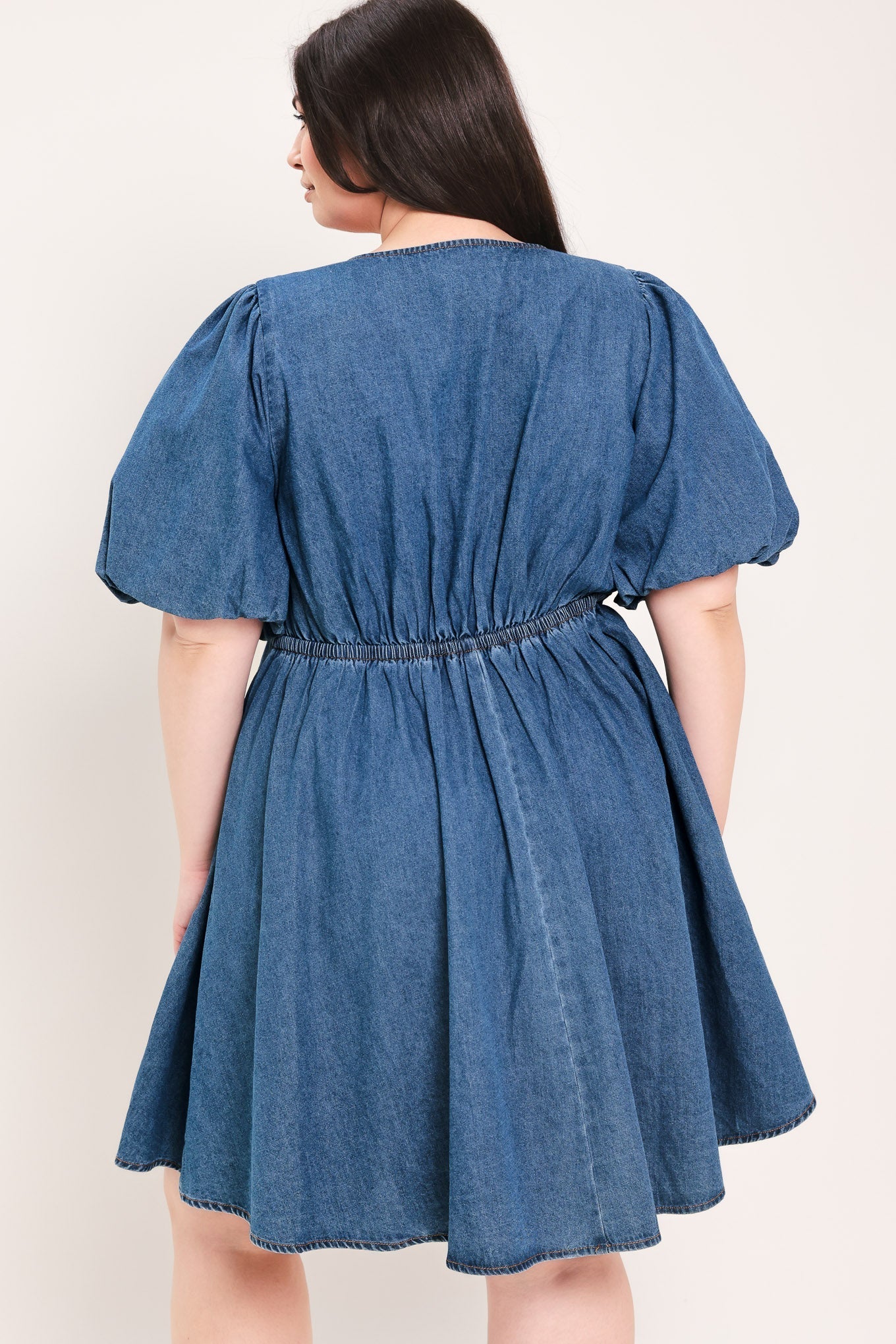 Soft Girl Denim Mini Dress in Medium Indigo Plus with V-neckline, puff sleeves, button-down detail, and circle skirt shown on model