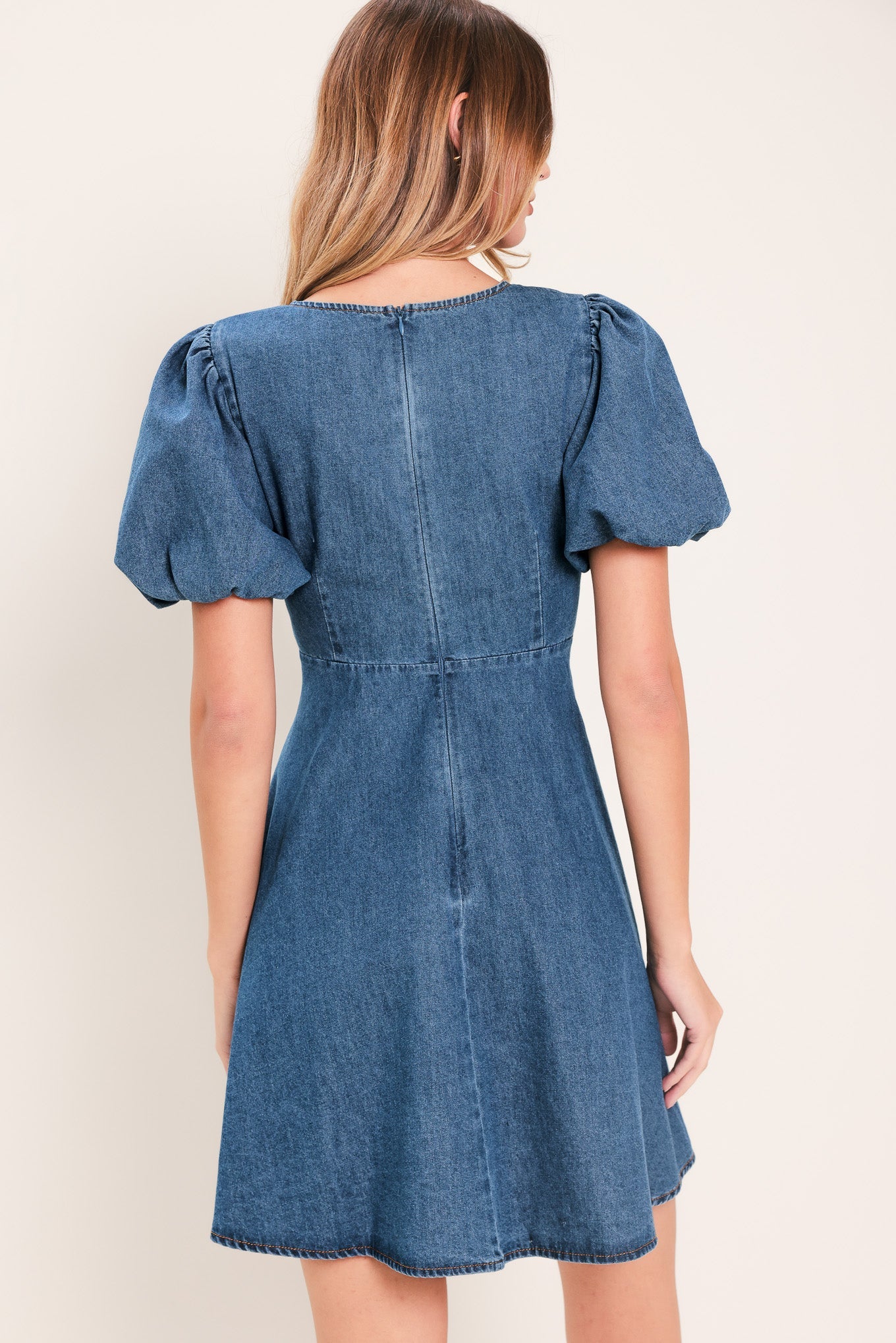 Soft Girl Denim Mini Dress in Medium Indigo with V-neckline, puff sleeves, button-down detail, and circle skirt shown on model