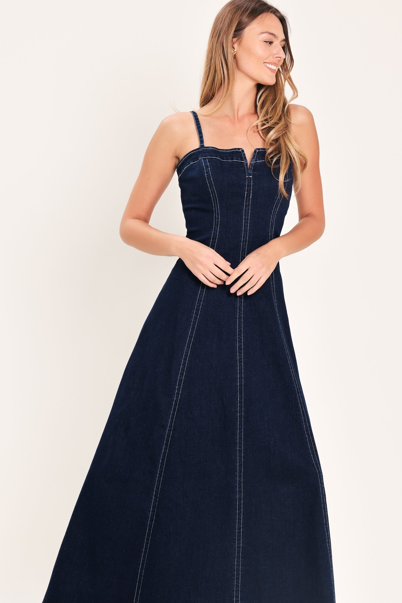 Denim Corset Midi Dress in Dark Indigo with straight neckline, V cut out, adjustable straps, circle skirt, and back zipper closure shown on model