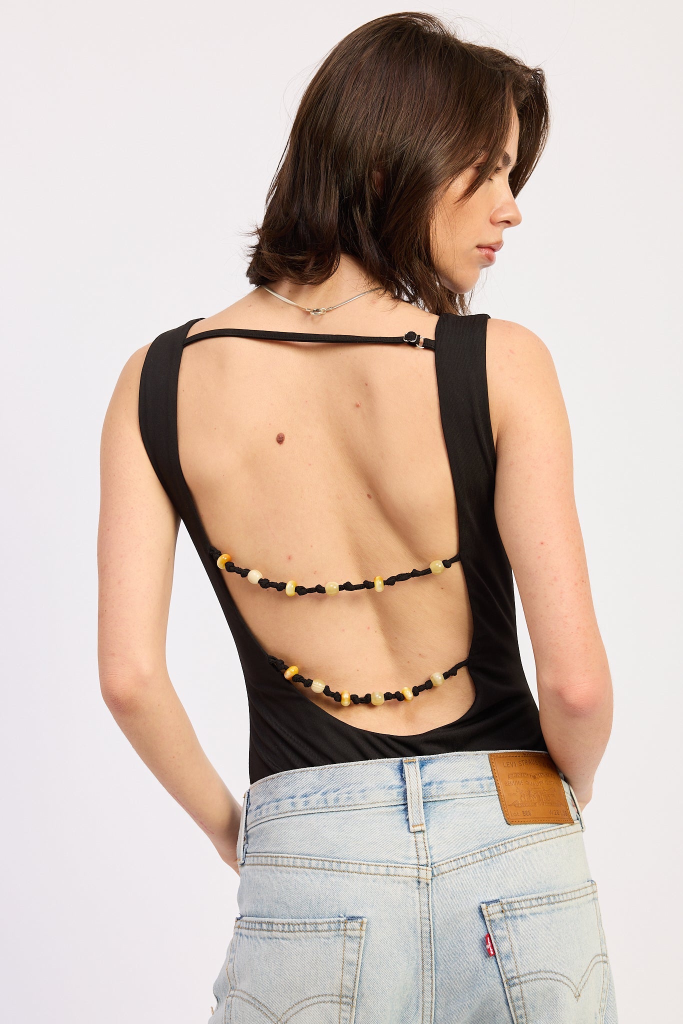 Solara Bodysuit in Black - styled tucked into trousers