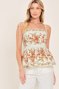 Villa Rosa Peplum Look Woven Top in Ivory with floral print, straight neckline, shoulder ties, smocked back, and peplum hem shown on model
