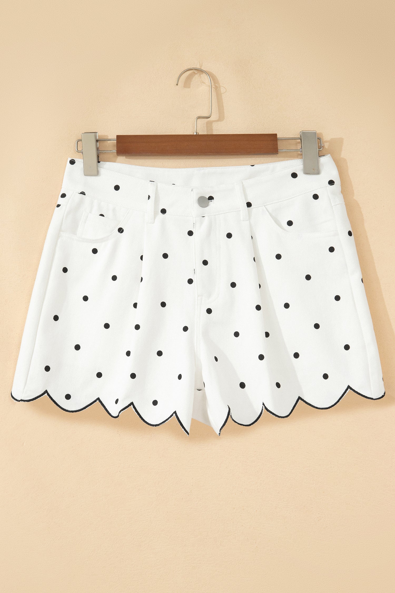White polka dot denim shorts detail showing embroidered scallop hem trim