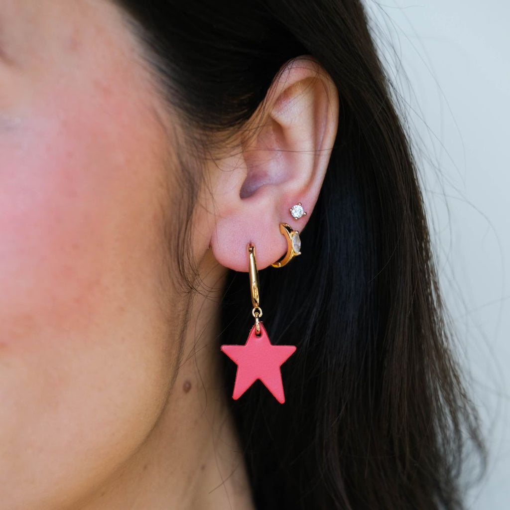 Crimson Tate Star Huggie Earrings styled on ear