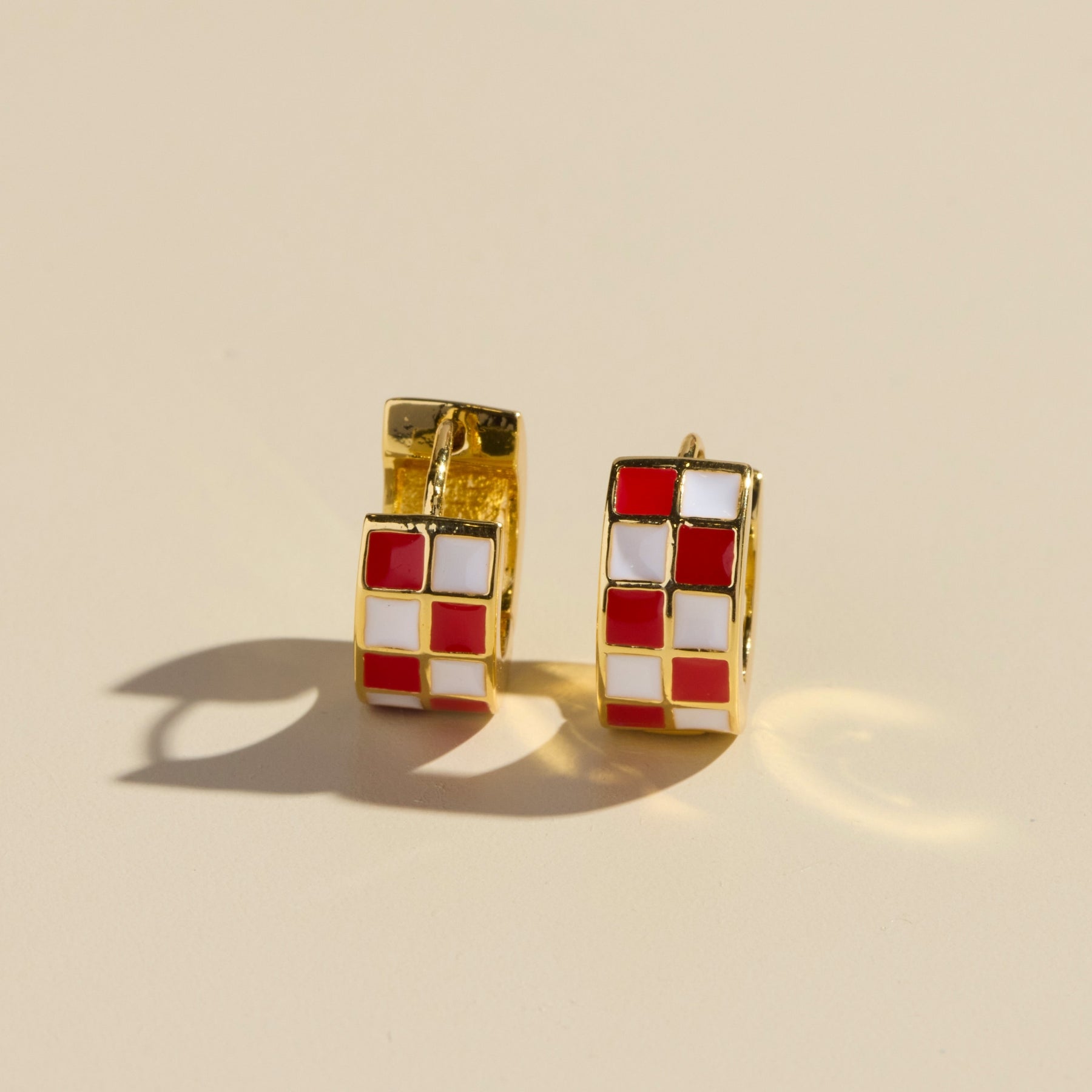 Red and white checkered enamel huggie hoop with hinge closure